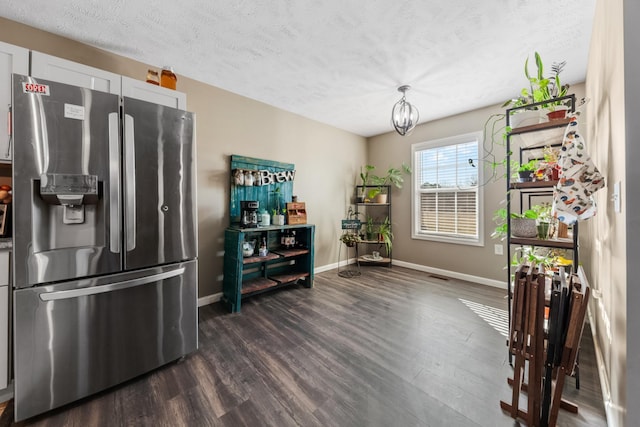 kitchen featuring dark wood-style floors, baseboards, a textured ceiling, stainless steel fridge, and a chandelier