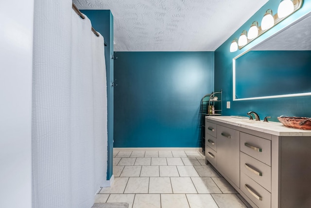 full bathroom featuring a textured ceiling, vanity, and baseboards