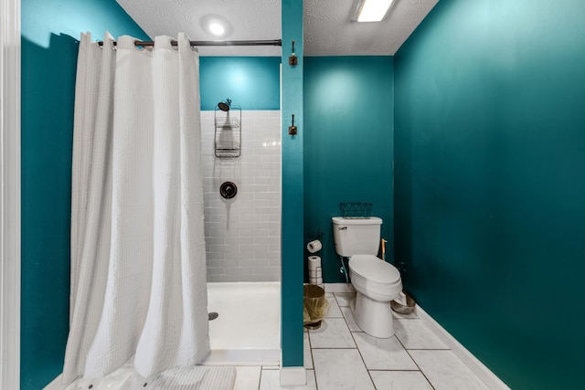 bathroom featuring toilet, a stall shower, a textured ceiling, tile patterned flooring, and baseboards