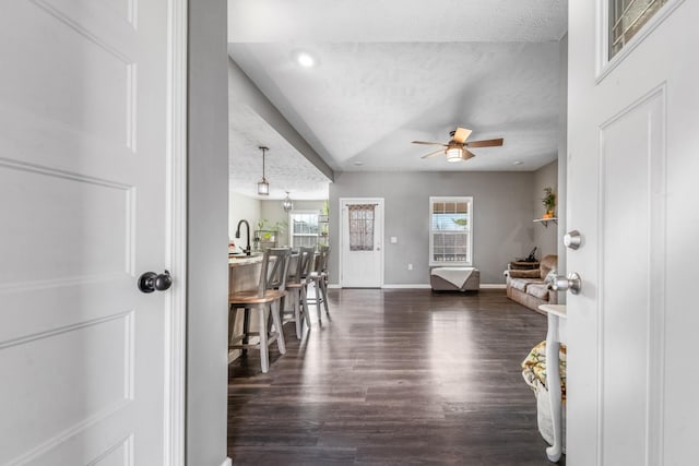 foyer featuring a ceiling fan, baseboards, recessed lighting, dark wood-type flooring, and a textured ceiling