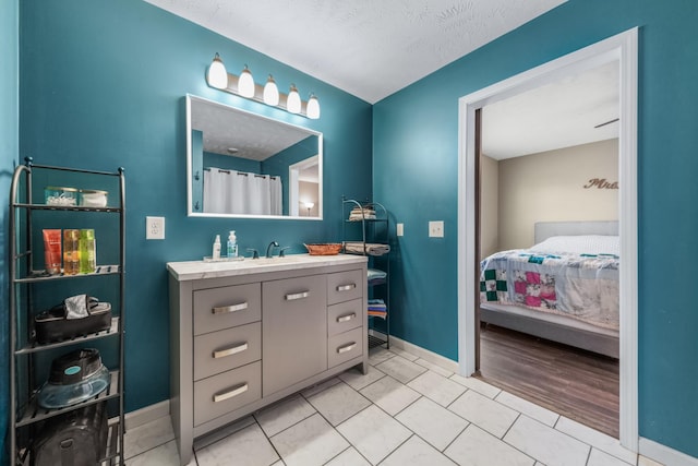 full bathroom with vanity, baseboards, and tile patterned flooring