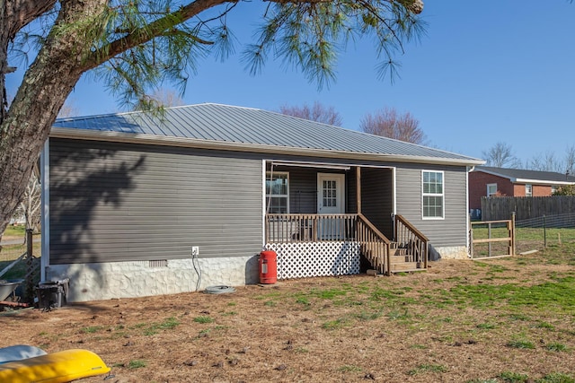 view of front of property with fence, covered porch, and metal roof