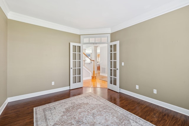 empty room with french doors, visible vents, wood finished floors, and decorative columns