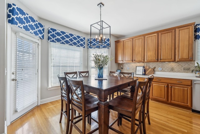 dining area featuring baseboards, a chandelier, and light wood finished floors