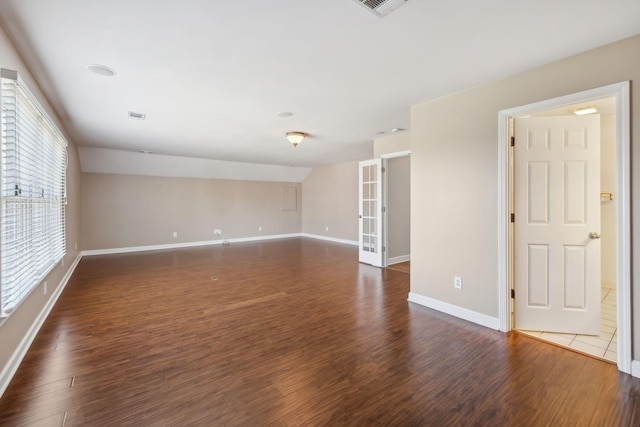 empty room featuring visible vents, baseboards, and wood finished floors