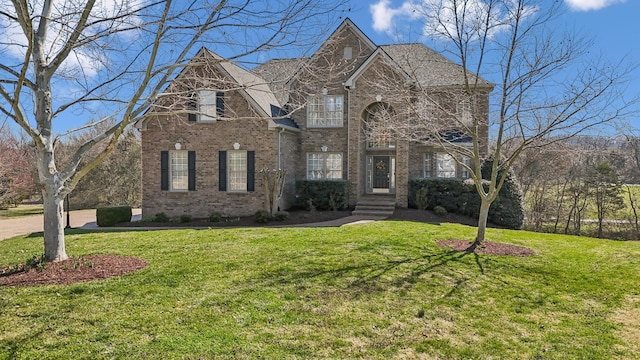 traditional-style house with brick siding and a front lawn