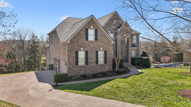 view of front facade with concrete driveway, an attached garage, a front yard, an outdoor pool, and brick siding