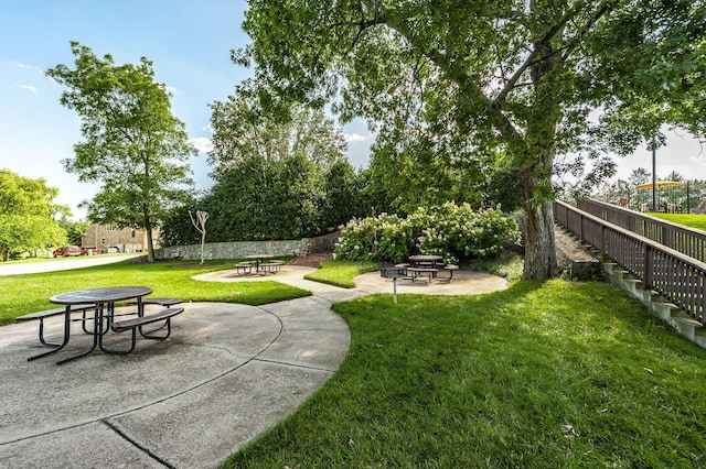 view of community featuring a patio, a yard, and fence