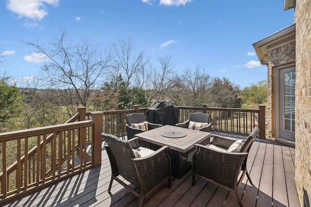 wooden deck with outdoor dining area and grilling area