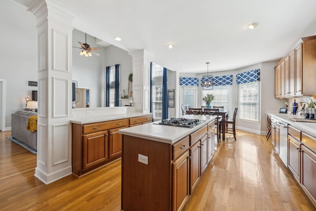 kitchen featuring light countertops, a ceiling fan, light wood-style floors, and ornate columns