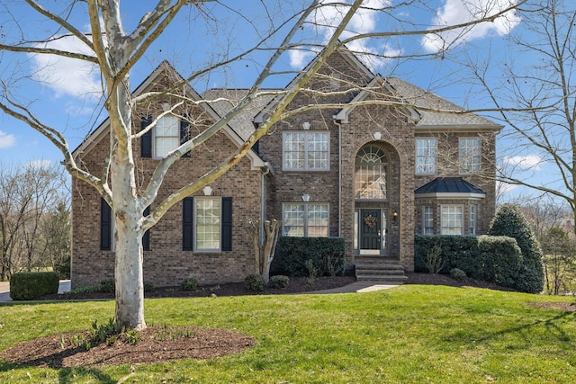 traditional-style house featuring brick siding and a front yard