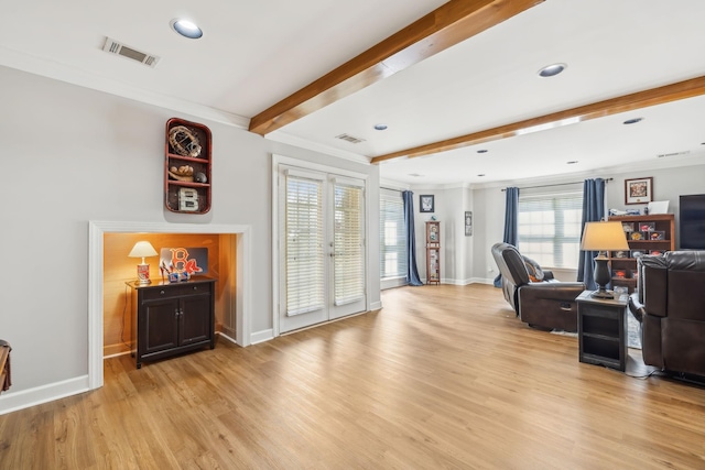 living room with beam ceiling, light wood-style flooring, baseboards, and visible vents