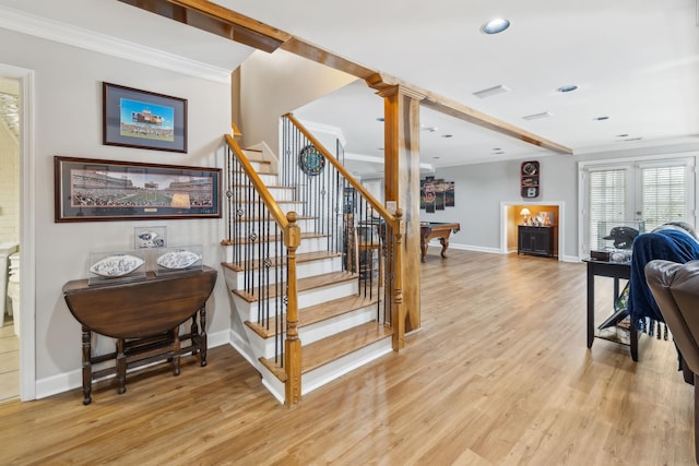 stairway featuring visible vents, crown molding, baseboards, and wood finished floors