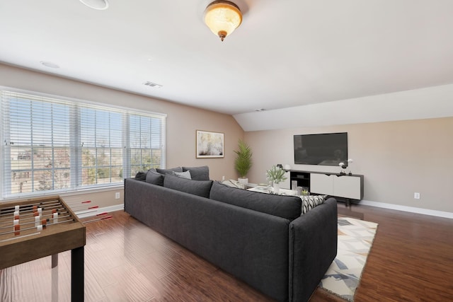 living room featuring vaulted ceiling, wood finished floors, visible vents, and baseboards