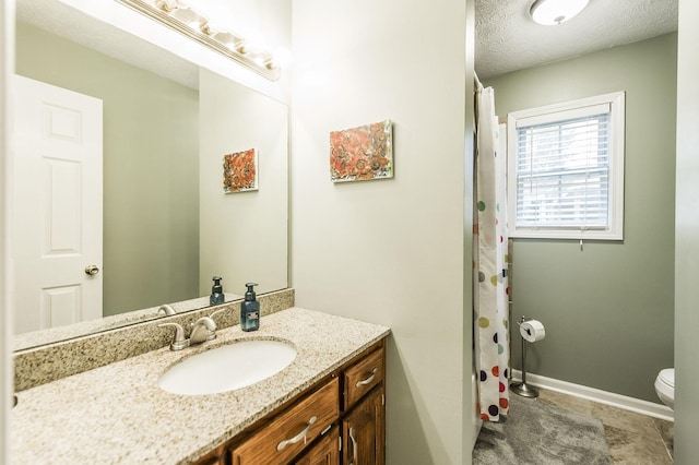 full bath featuring vanity, a shower with shower curtain, baseboards, a textured ceiling, and toilet