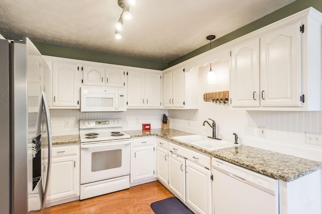 kitchen featuring a sink, white appliances, light wood-style flooring, and white cabinets