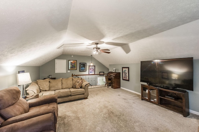 carpeted living area with vaulted ceiling, a ceiling fan, baseboards, and a textured ceiling