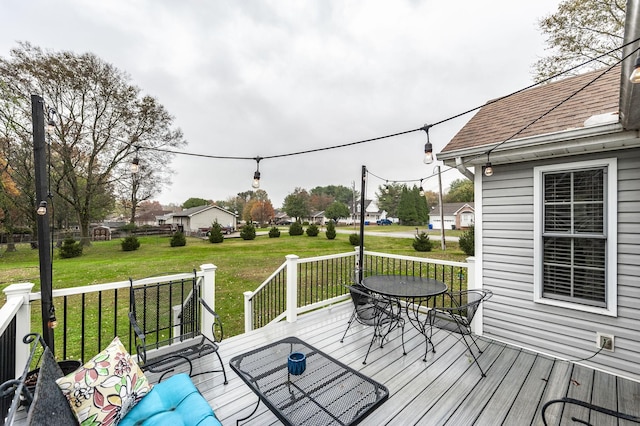 deck featuring outdoor dining area and a yard