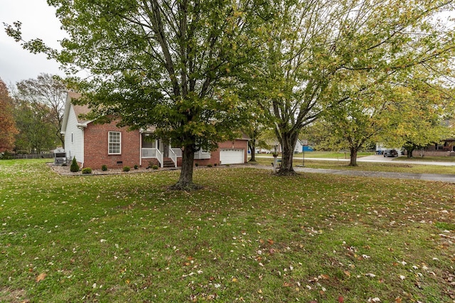 view of yard featuring aphalt driveway and an attached garage