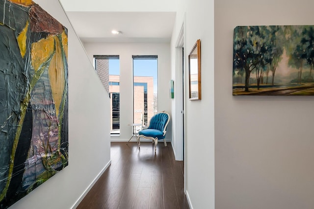 corridor featuring dark wood-type flooring and baseboards