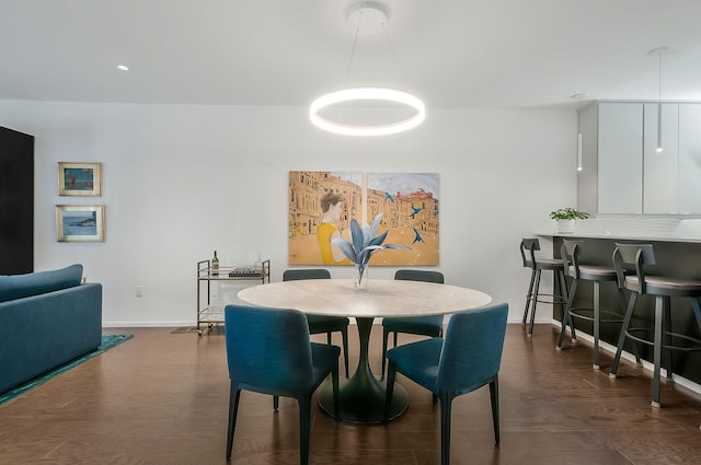 dining room featuring dark wood finished floors and baseboards