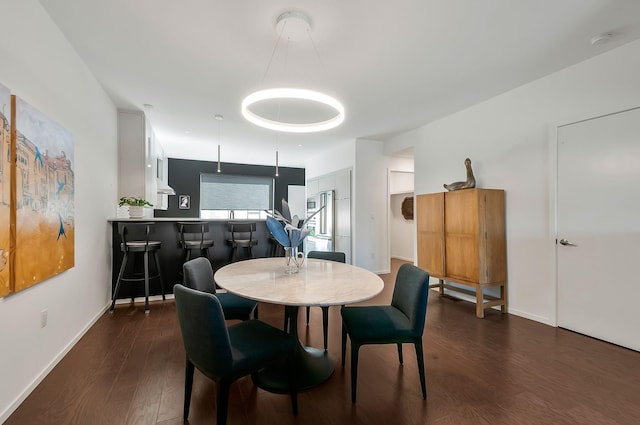 dining area with dark wood-type flooring and baseboards