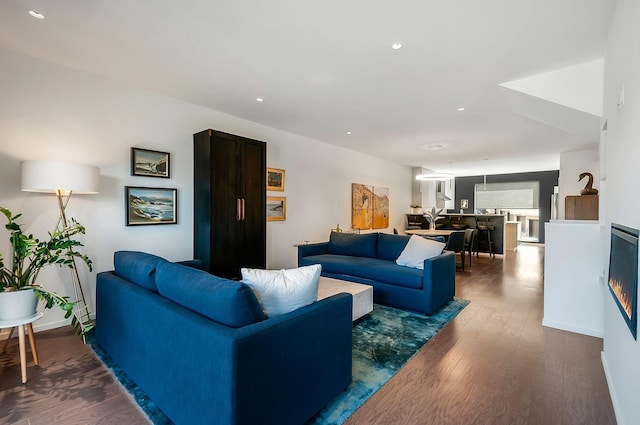 living area featuring recessed lighting and dark wood-style floors