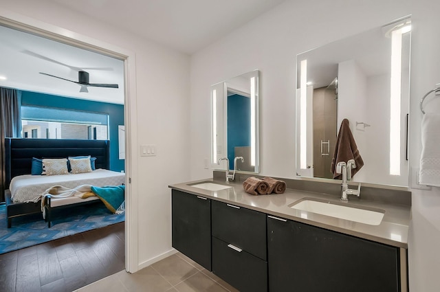 ensuite bathroom featuring double vanity, ensuite bath, a ceiling fan, and a sink