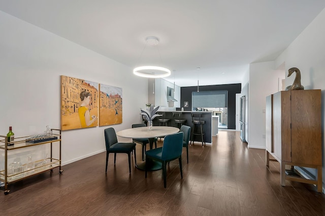 dining area with dark wood-type flooring and baseboards