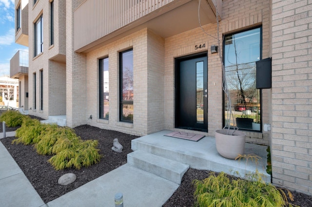 view of exterior entry featuring brick siding