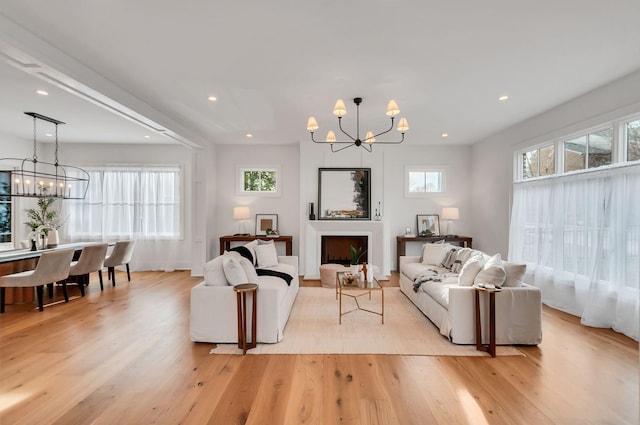 living area with plenty of natural light, light wood-style floors, and a chandelier