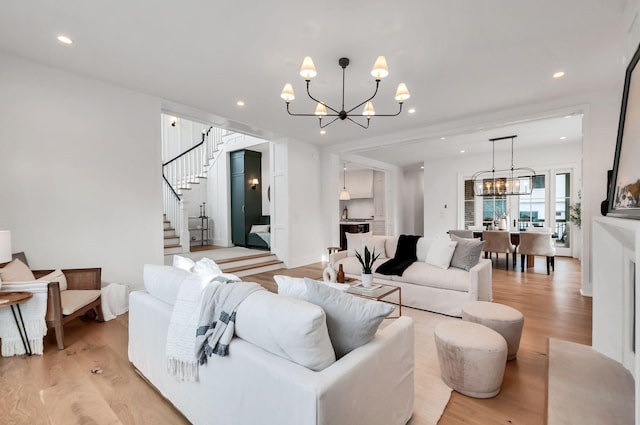 living room featuring recessed lighting, stairway, light wood-style floors, and a chandelier