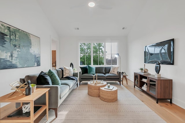 living room featuring light wood-type flooring, visible vents, a ceiling fan, and vaulted ceiling