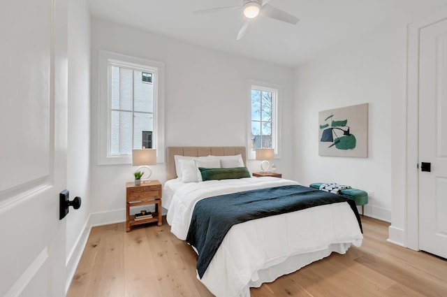 bedroom featuring light wood-style flooring, baseboards, and ceiling fan