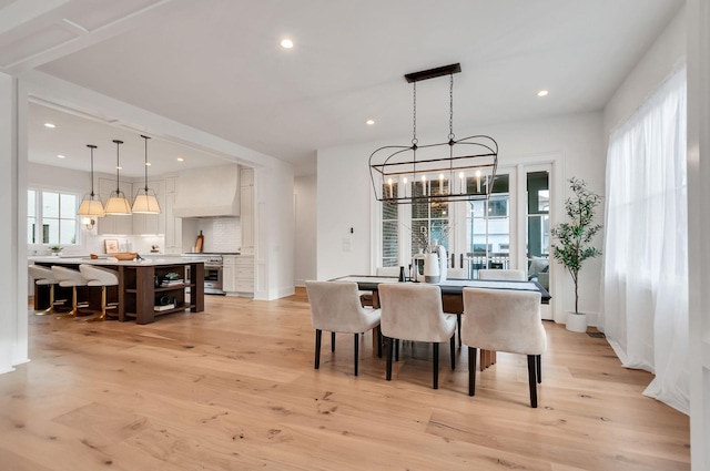 dining room with an inviting chandelier, recessed lighting, and light wood finished floors