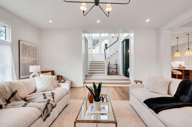 living area featuring light wood finished floors, stairway, and recessed lighting