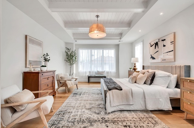 bedroom featuring beam ceiling and light wood-style flooring