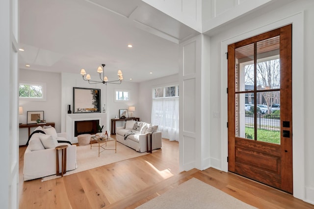 foyer with a chandelier, plenty of natural light, and wood finished floors