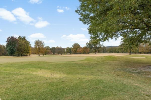 view of home's community featuring a yard and view of golf course