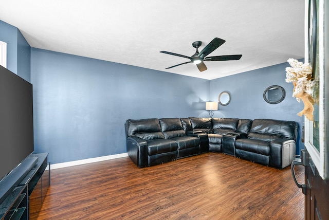 living room featuring baseboards, a ceiling fan, and wood finished floors