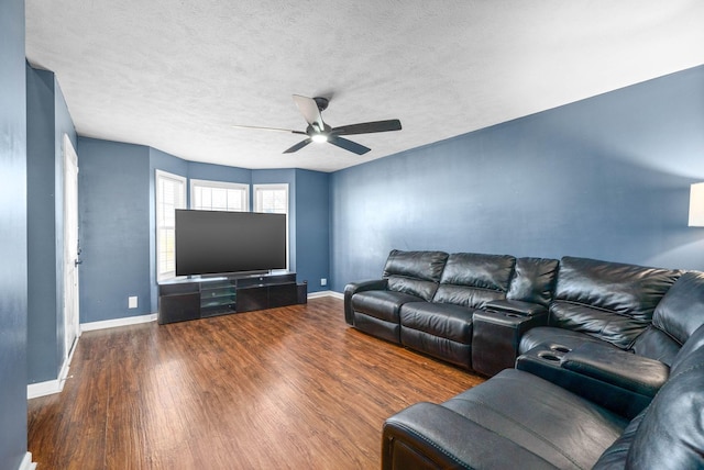 living area featuring a textured ceiling, baseboards, a ceiling fan, and wood finished floors