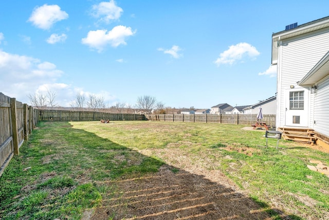 view of yard featuring entry steps and a fenced backyard