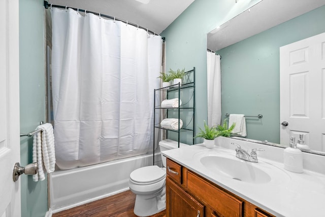 bathroom with shower / tub combo with curtain, toilet, wood finished floors, and vanity