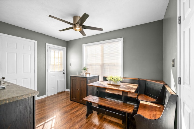 dining room with dark wood-style floors, baseboards, and ceiling fan