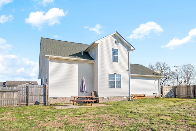 rear view of property featuring crawl space, a yard, a shingled roof, and fence