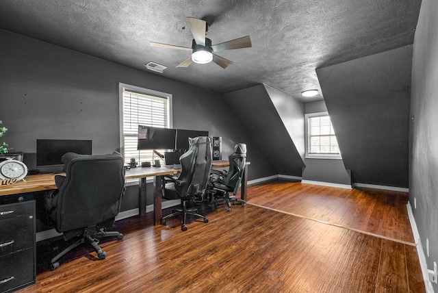 office featuring visible vents, baseboards, ceiling fan, hardwood / wood-style flooring, and a textured ceiling