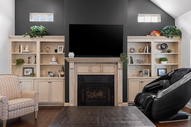 living area with vaulted ceiling, dark wood-style floors, and a fireplace