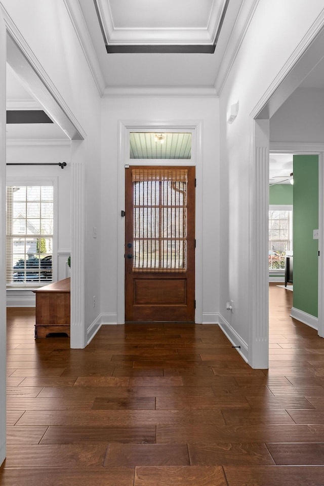 entrance foyer featuring dark wood-style floors, crown molding, and baseboards