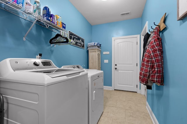 laundry area featuring laundry area, baseboards, visible vents, and separate washer and dryer