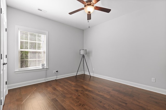 spare room featuring visible vents, ceiling fan, baseboards, and wood finished floors